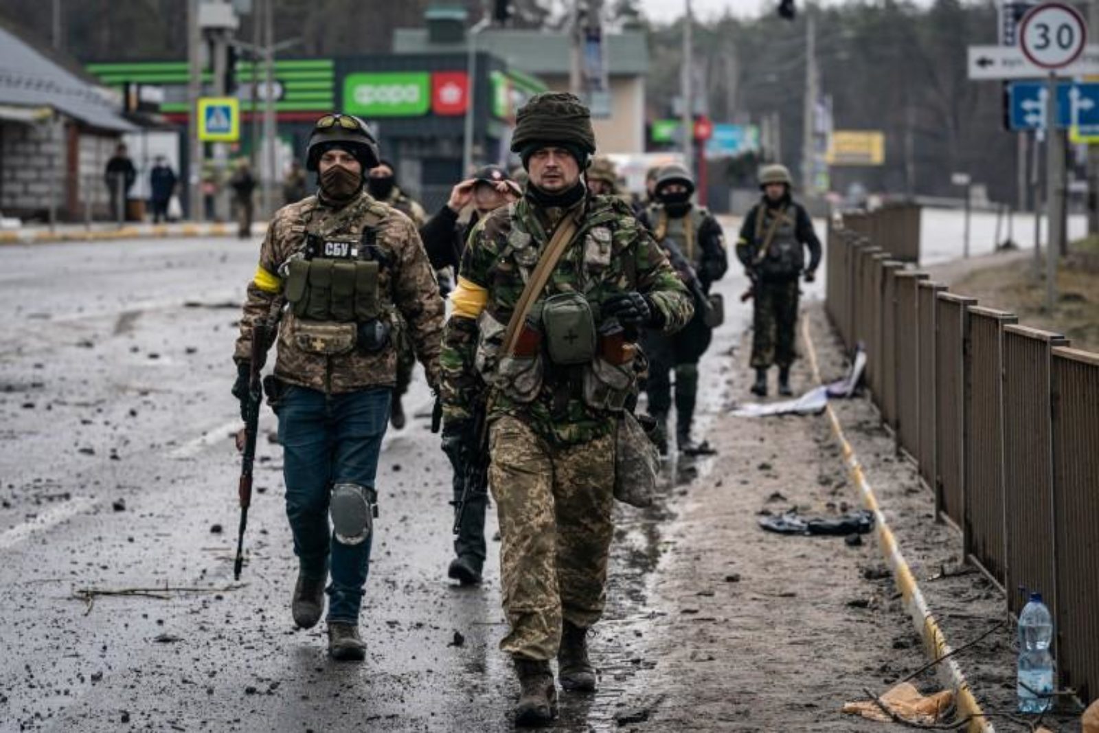 Soldiers walking down a blown out street, in Ukraine